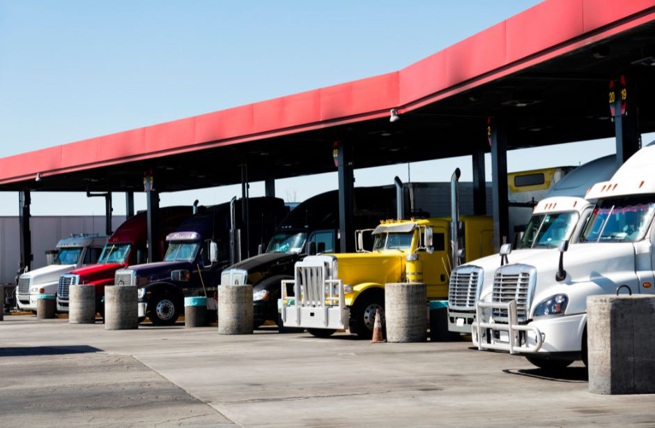 Fleet of commercial vehicles including trucks and vans parked outside a business depot